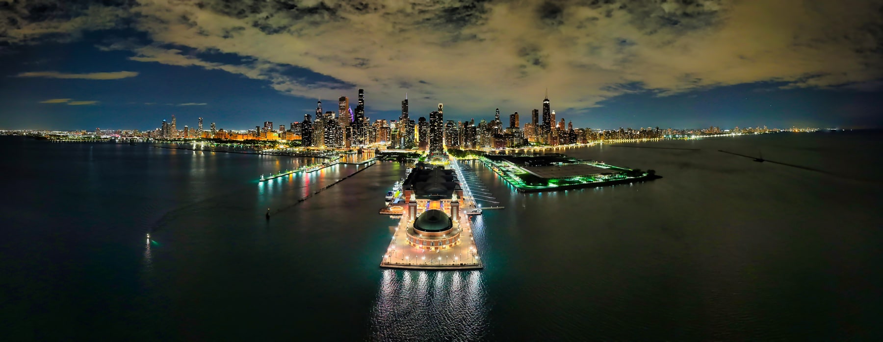 Navy Pier and the illuminated Chicago skyline seen across Lake Michigan at night.